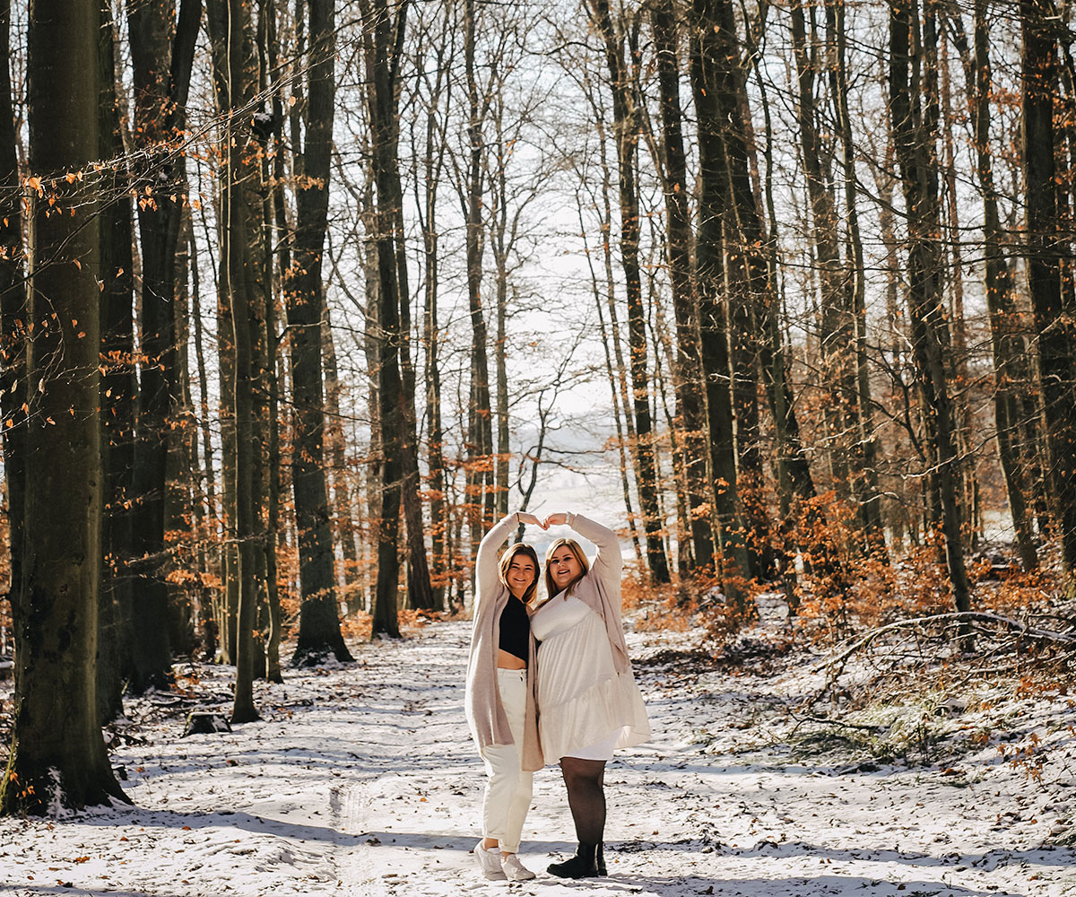 Hebammen Vanessa Hildmann und Kim Spottog vom Geburtshaus Langgöns formen eine Herz mit ihren Händen im Hardtwald in Langgöns im Winter